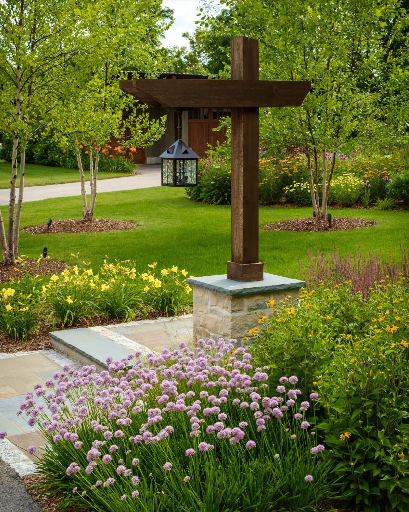 Custom entry post with allium blooms and stone walkway