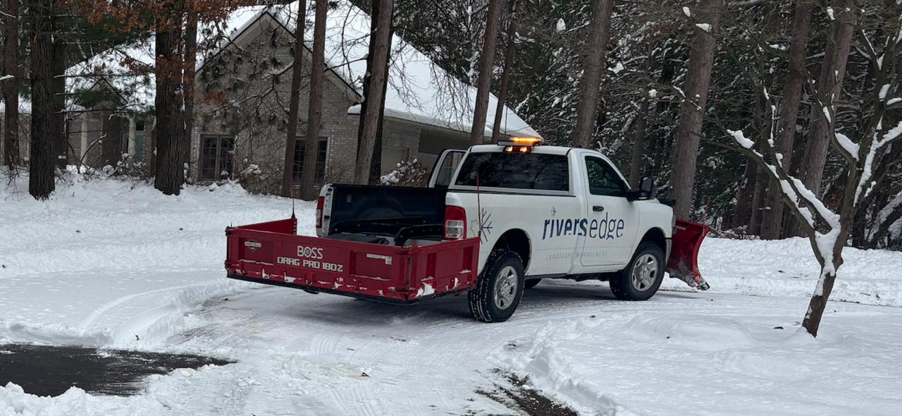 Rivers Edge branded truck with red plow